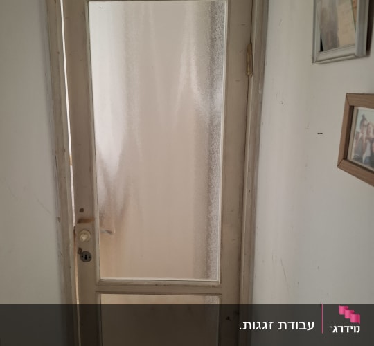דלת עם זכוכית מטושטשת במסגרת עץ